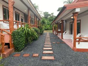 a walkway leading to a building with a house at Arya Bungalow in Phra Ae beach