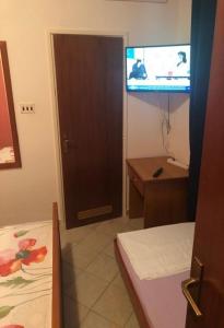 pokój z drzwiami, telewizorem i łóżkiem w obiekcie Apartments Denko w mieście Kali