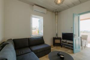 a living room with a couch and a tv at Dipaton House in Vasa 2 in Vasa Kilaniou