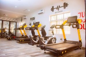 a gym with several tread machines in a room at Lekki Aprt Pool Gym sleeps 6 FreeP Tv WiFi in Ikota