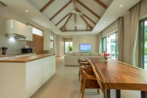 Completed 09-10-2024 Beautiful 4BR V139 في تشالونج: مطبخ وغرفة معيشة مع طاولة خشبية