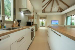 Completed 09-10-2024 Beautiful 4BR V139 في تشالونج: مطبخ بخزائن بيضاء وطاولة خشبية