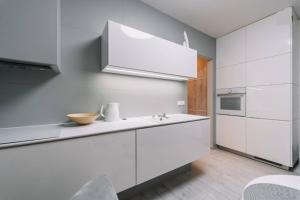 a kitchen with white cabinets and a sink at E3 Luxury OldTown Apt w Free Garage, Supermarket, FastWifi, Unlimited Music, Prime Video, Aircon in Košice