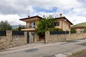 a house on the side of a stone wall at El Castillo in La Adrada