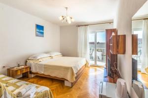 a bedroom with two beds and a flat screen tv at Apartments and Rooms Happiness in Tučepi