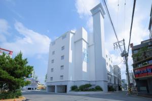 晋州市Aank Air Hotel Jinjuseong的街角的一栋白色建筑