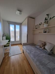 a bedroom with a bed and a large window at Waldorf Apartment in Ljubljana