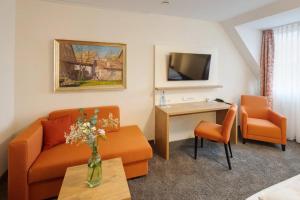 a living room with a couch and a table at Landhotel Steigenhaus in Untermünkheim