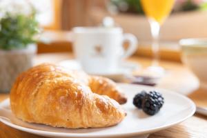 a plate with two croissants and a blackberry on a table at Landhotel Steigenhaus in Untermünkheim