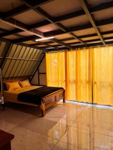 a bedroom with a bed with yellow curtains in it at Mount River Homestay in Palakkad