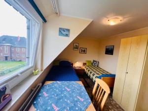 a small room with two beds and a window at Ferienwohnung Janssen in Borkum +15 photos