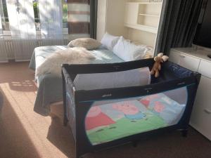 a baby crib in a room with a bed at Kiek mol wedder in in Borkum