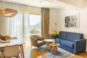 a living room with a blue couch and a table at Budva Harmonia in Boreti