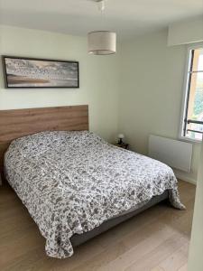 una camera da letto con un letto con un piumone di Park avenue, 6 pers, plein centre, parking et linge inclus a Le Touquet-Paris-Plage