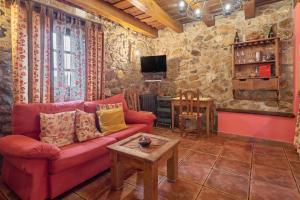 a living room with a red couch and a table at El Apartamento in Robledo de la Guzpeña