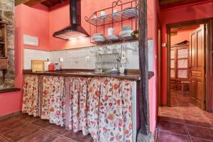 a kitchen with red walls and a counter with dishes at El Apartamento in Robledo de la Guzpeña