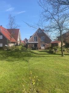 a large house with a yard with green grass at Haus Petra in Borkum