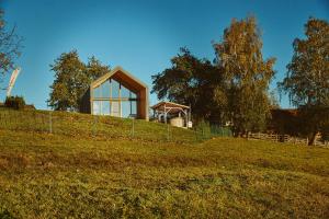 a house sitting on top of a grassy hill at Scandinave Chalet Bran in Zărneşti