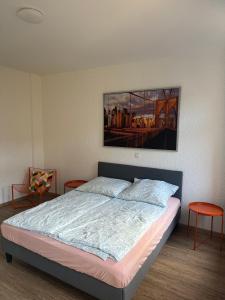 ein Schlafzimmer mit einem Bett und einem Gemälde an der Wand in der Unterkunft MH Apartments in Erfurt