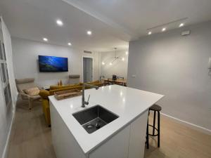 een keuken met een spoelbak en een woonkamer bij La Casa de Lineros in Córdoba