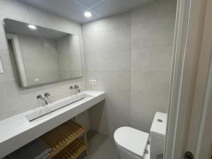 een badkamer met een wastafel, een toilet en een spiegel bij La Casa de Lineros in Córdoba