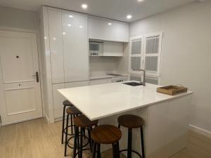 een keuken met een wit aanrecht en krukken bij La Casa de Lineros in Córdoba +10 foto's