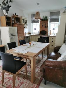 a kitchen with a wooden table and chairs in a room at Kö's Apartment in Jena +11 photos