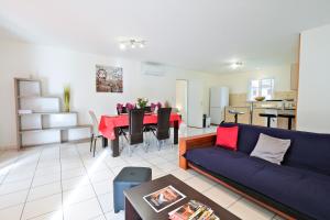 a living room with a blue couch and a table at Le Barradis avec Piscine et Clim in Savignac-les-Églises