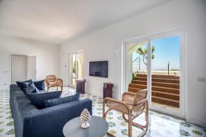 a living room with a blue couch and a tv at Villa La Luce 5 Bedrooms in the Town Center by Feeling Italy in Massa Lubrense