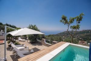 a villa with a swimming pool and an umbrella at Villa La Luce 5 Bedrooms in the Town Center by Feeling Italy in Massa Lubrense