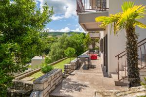 a house with a palm tree next to a building at Apartments Zulijani House Helis B1 & B6 in Rabac