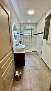 a bathroom with a sink and a tub and a mirror at Le Domaine Des Yèbles - Appartement Calme et élégant in Avon +21 photos