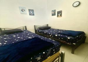 two beds sitting next to each other in a bedroom at Sulong Inn - Private Pool Homestay in Kuantan, Pantai Sepat in Kuantan +21 photos