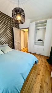 a bedroom with a bed and a chandelier at Le Domaine Des Yèbles - Appartement Calme et élégant in Avon