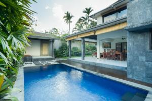 a swimming pool in the backyard of a house at Samaja Beachside Villas in Seminyak