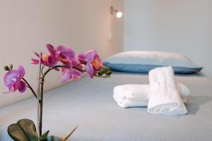 un jarrón con flores moradas en una cama en Aosta Theater Home, en Aosta