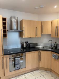 a kitchen with wooden cabinets and a stove top oven at Heart of YORK in York