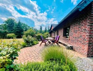 a brick patio with two chairs and a table at Ferienhaus am Rande des Spreewald in Heinersbrück