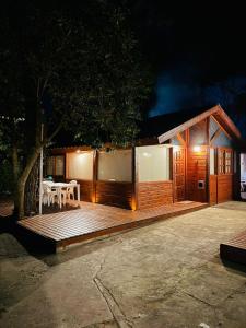 a small cabin with a table and chairs on a deck at Cabañas Entre Pinos in Villa Gesell