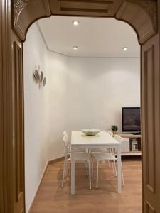 a dining room with a white table and chairs at Céntrico apartamento a estrenar in Bilbao