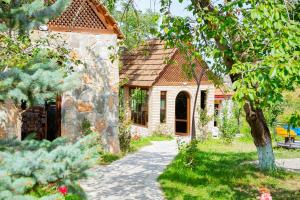 a stone house with a pathway leading to a yard at Qachaquch Forest in Qusar