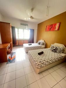 una sala de estar con dos camas y un sofá en The UrBan Selesa Hillhomes, Bukit Tinggi Bentong, en Bentong