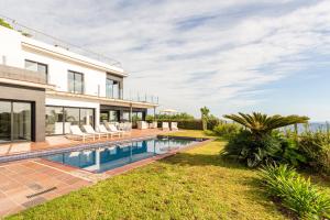 an exterior view of a house with a swimming pool at Villa Roman in Lloret de Mar