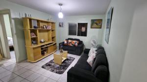 a living room with a couch and a chair at Apartamento da Tia Jaci in Paulista