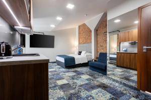 波兹南Apartamenty Browar Luxury Old Town Poznań 24h的一间带床和厨房的酒店房间
