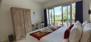 une chambre avec un grand lit avec une grande fenêtre dans l'établissement The Lebak Sari Guesthouse, à Umalas