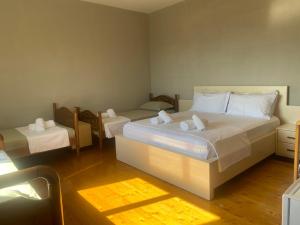 a bedroom with a large white bed and two tables at Meti Guest House in Krujë