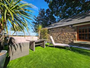 a garden with a bench and a table and a stone building at The Manor in Bishop Auckland