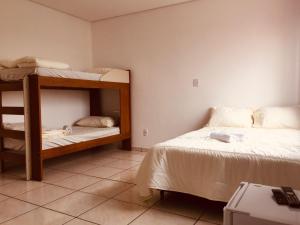 a bedroom with two bunk beds and a desk at Pousada Lagus Pan in Capitólio