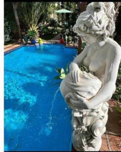 a statue of a woman sitting next to a swimming pool at Mijaa pueblo Paradise villa anex in Mijas